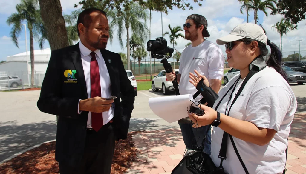 man in business suit speaking with video crew