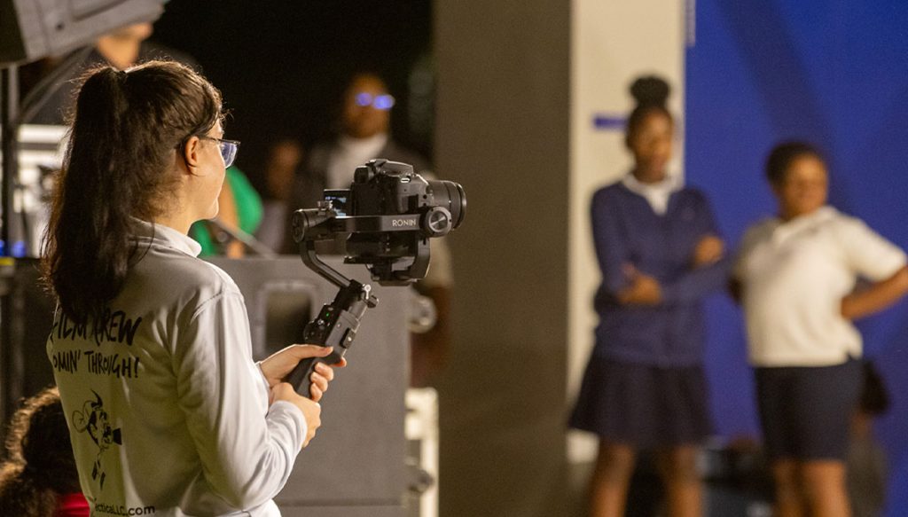camerawoman filming two children on stage