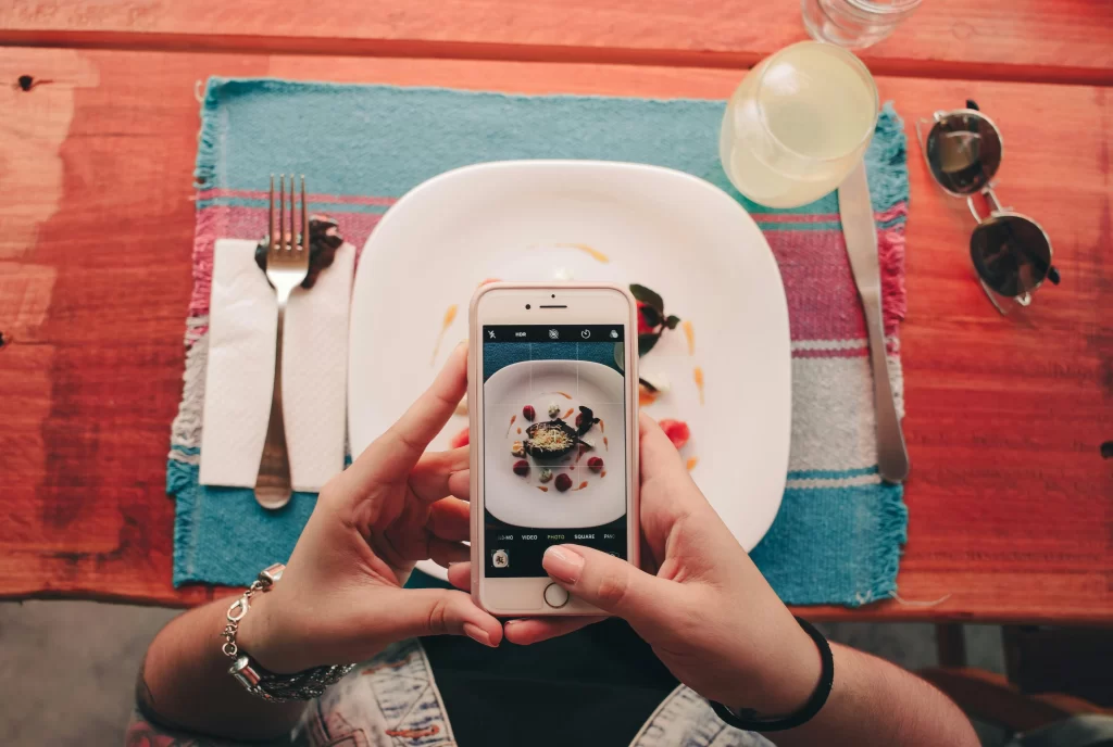 woman photographing food with her cellphone