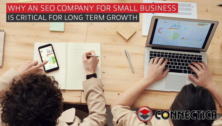 Two workers at a desk looking a analytics on a laptop and smartphone