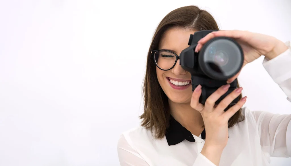 woman pointing a camera while smiling
