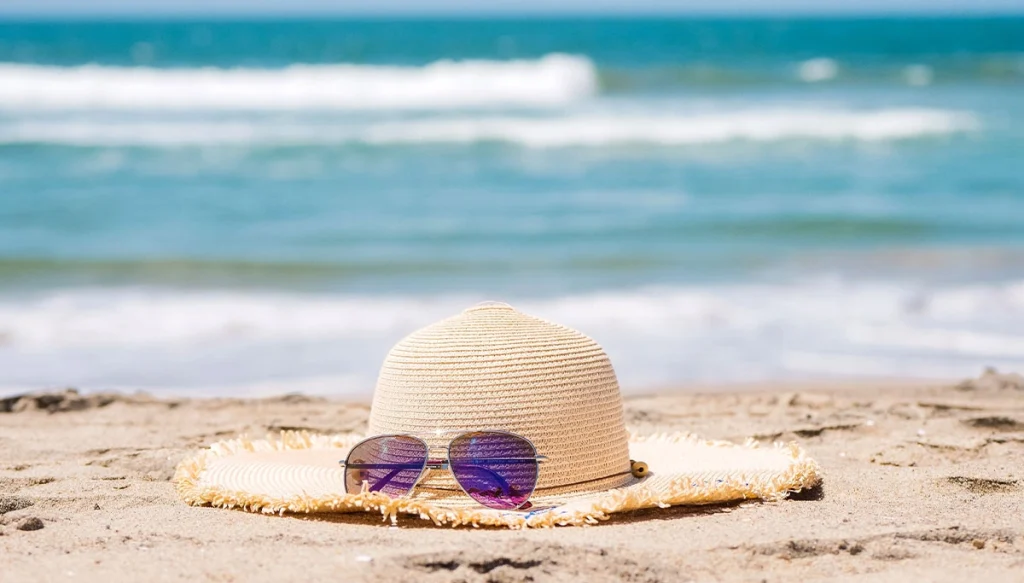 A hat with sunglasses on the beach