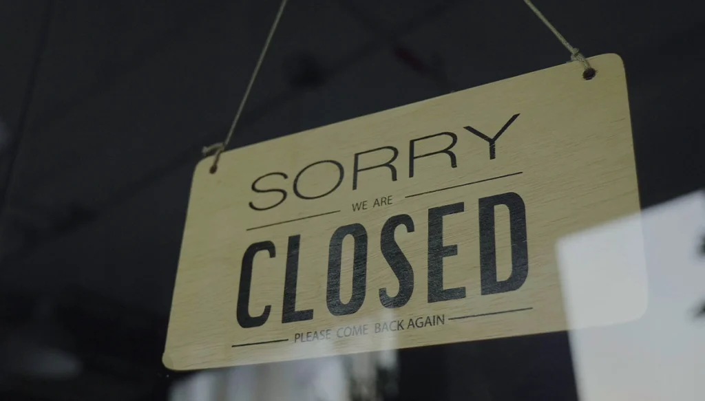 Still Image of Sorry We Are Closed Sign In Empty Fancy Fashion Boutique With Stylish Formal Clothes Message